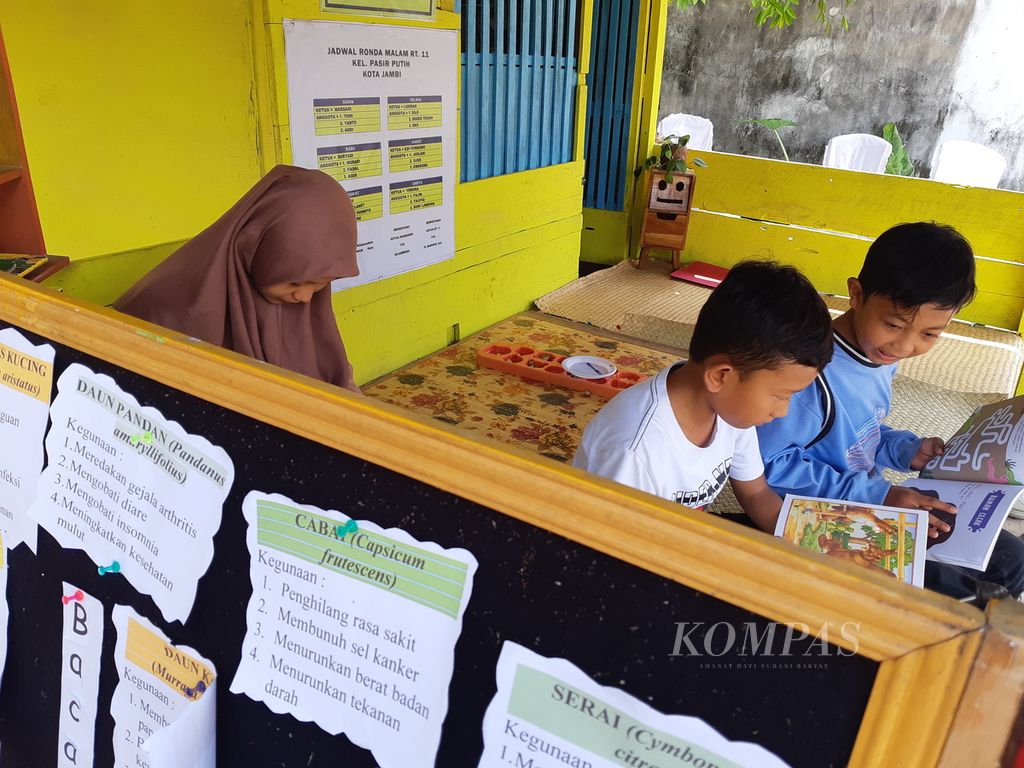 Anak-anak memanfaatkan pojok baca yang dibangun swadaya oleh warga di RT 011 Pasir Putih, Kota Jambi, Selasa (28/6/2022). Kegiatan itu bagian dari Program Kampung Bantar yang bertujuan menarik partisipasi masyarakat dalam pembangunan kota.