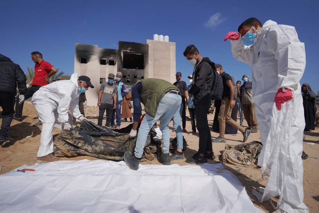 Petugas kesehatan Palestina menggali kuburan massal jenazah yang dikebumikan tentara Israel di kompleks Rumah Sakit Nasser di Khan Younis, Gaza selatan, Minggu (21/4/2024). 