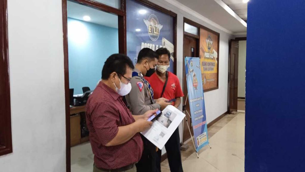 Petugas membantu warga dalam memproses tilang elektronik di Ditlantas Polda Metro Jaya.