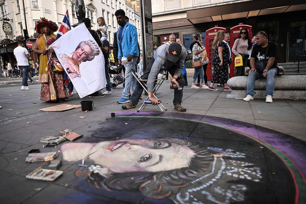 Seorang seniman melukis wajah Ratu Elizabeth II di area Trafalgar Square, London, Inggris, Minggu (11/9/2022). 