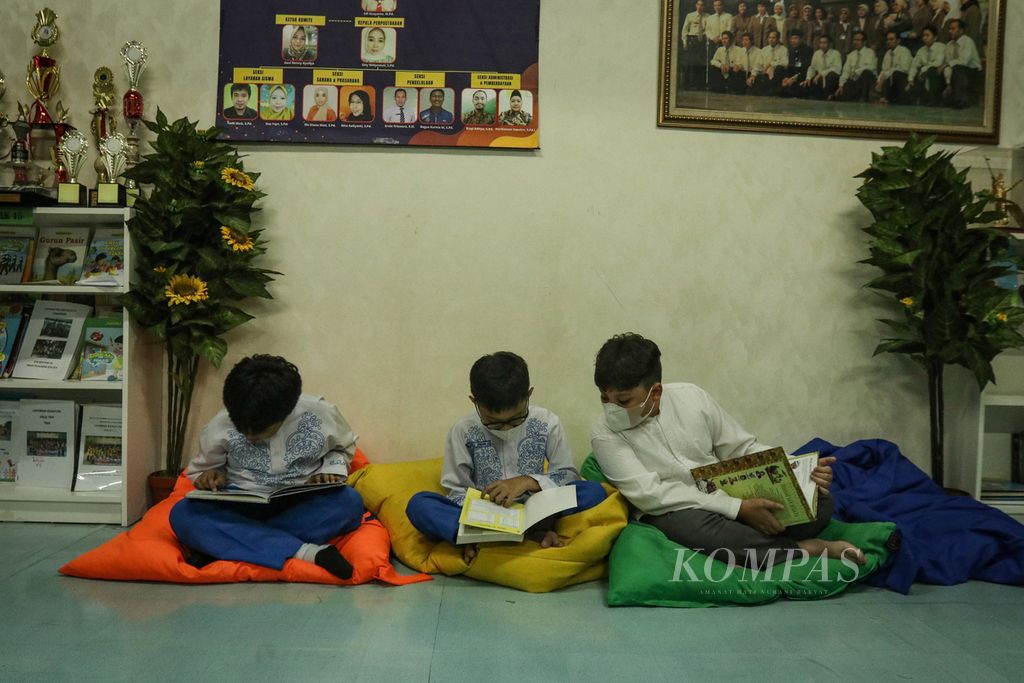 Tiga siswa membaca buku di Perpustakaan SD Negeri Menteng 02, Jakarta Pusat, Jumat (3/2/2023). 