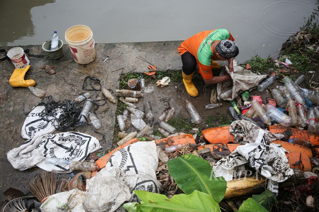 Petugas mengumpulkan sampah plastik yang didominasi botol air kemasan dari Sungai Ciliwung di kawasan Sawah Besar, Jakarta Pusat, Selasa (30/1/2024). Sampah masih menjadi persoalan utama yang mendera Sungai Ciliwung.
