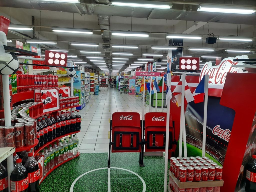 Coca-Cola yang bermitra dengan Federasi Asosiasi Sepak Bola Internasional (FIFA) dalam Piala Dunia 2022 bekerja sama dengan swalayan Harmony, Tangerang Selatan guna mendirikan pojok pameran produk berbentuk stadium, Selasa (8/11/2022). Beragam pernak-pernik, seperti lapangan sepak bola mini, kursi penonton, dan bendera sejumlah negara, dipasang untuk menarik minat pembeli.