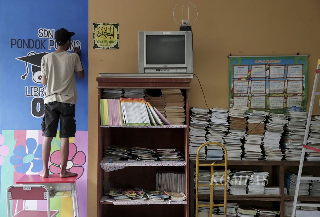 Doni menggambar mural bertema budaya literasi di perpustakaan SDN Pondok Pucung 2, Tangerang Selatan, Banten, Jumat (13/9/2019). Pihak sekolah menyulap ruang perpustakaan menjadi lebih berwarna dengan mural untuk merangsang anak-anak betah membaca buku di perpustakaan. 