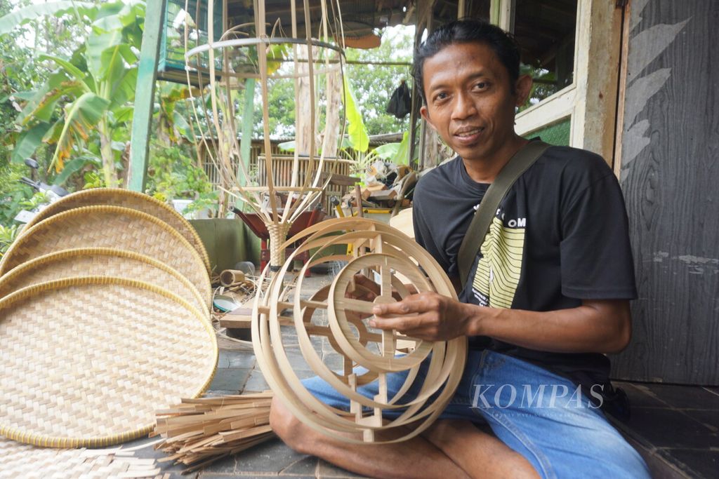 Suratno (33), Ketua Paguyuban Wong Mujur, menunjukkan hasil karya perajin bambu di Desa Mujur, Kecamatan Kroya, Kabupaten Cilacap, Jawa Tengah, Selasa (4/7/2023).