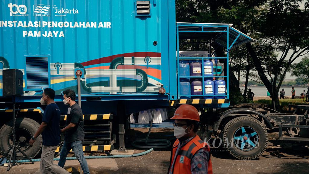 Petugas melewati truk instalasi pengolahan air PAM Jaya dalam peringatan Hari Air Sedunia 2022 di Waduk Cincin, Kelurahan Papanggo, Tanjung Priok, Jakarta Utara, Selasa (22/3/2022). 