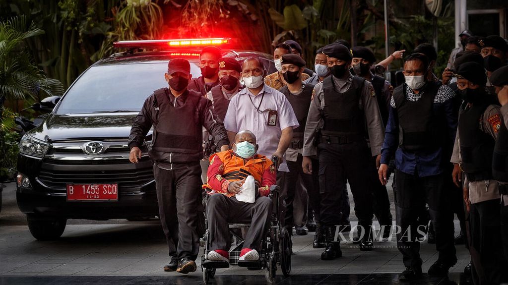 Gubernur Papua Lukas Enembe dibawa dengan kursi roda ketika tiba di gedung Komisi Pemberantasan Korupsi (KPK), Jakarta, Kamis (12/1/2023). Tim medis RSPAD Gatot Subroto menyatakan kondisi Lukas Enembe sudah bisa menjalani pemeriksaan di KPK.