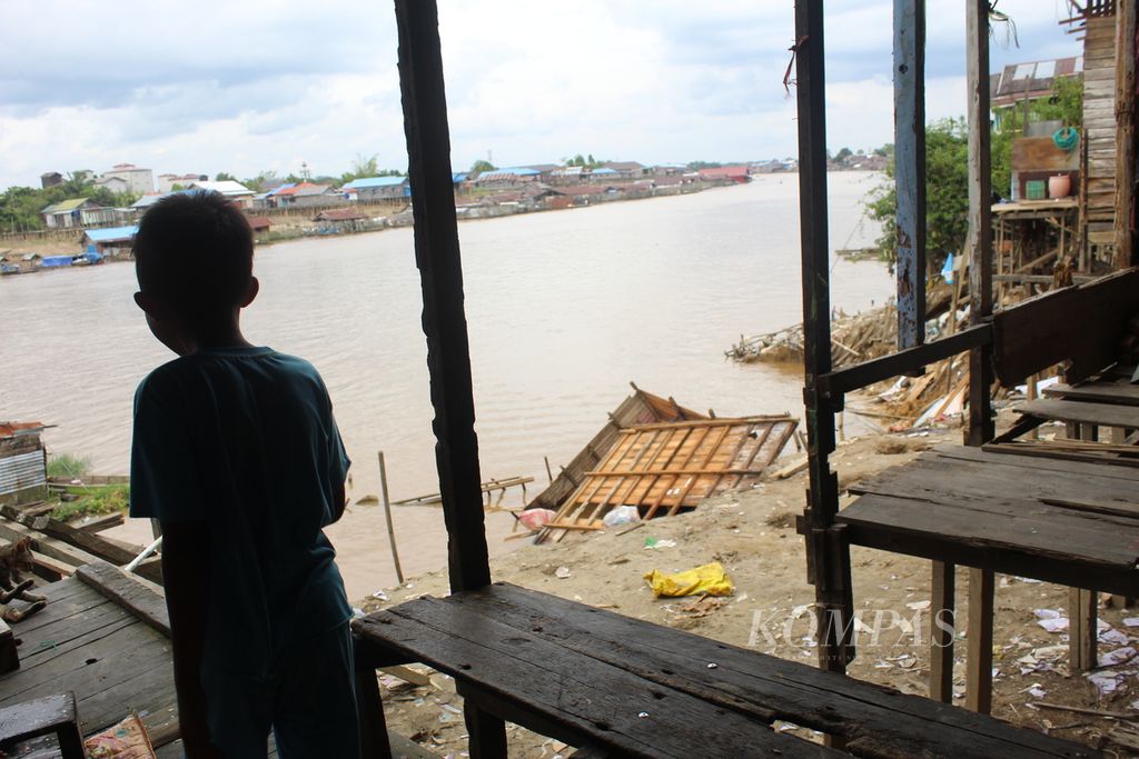 Seorang anak bermain di bangunan rumah yang terdampak abrasi di pinggir Sungai Kahayan, Kota Palangkaraya, Kalimantan Tengah, Minggu (8/1/2023). Empat rumah rusak, tiga di antaranya ambruk.