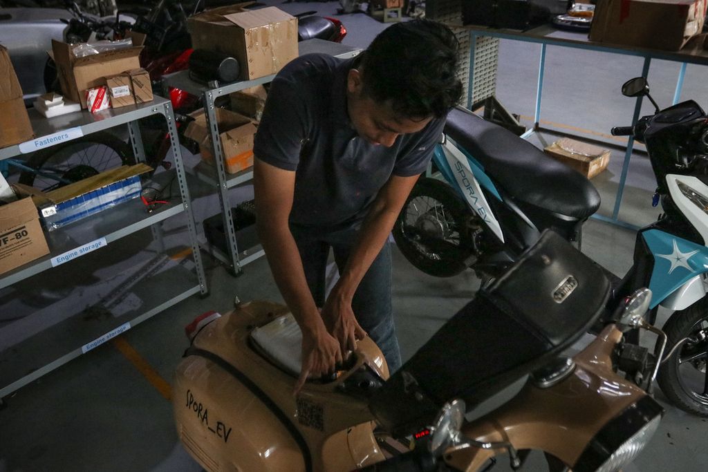 A mechanic checks a motorcycle battery that has been converted to an electric motorbike at the Spora EV workshop, North Serpong, South Tangerang, Thursday (23/3/2023). A total of 21 workshops have been certified by the Ministry of Transportation to carry out the program to convert fuel-based motorbikes to electric motorbikes.