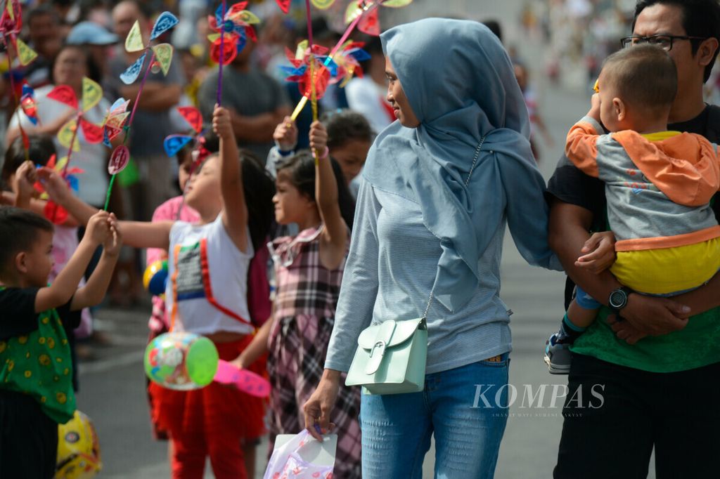 Anak-anak bermain kincir angin saat acara festival bunga di Kota Tomohon, Sulawesi Utara, Kamis (8/8/2019). Kawasan pasar dan ruang publik lainnya menjadi tempat interaksi antarwarga mayoritas Kristen dengan umat beragama lain, seperti Islam, Buddha, dan Katolik. Tomohon masuk menjadi salah satu kota toleran yang menghormati keberagaman.