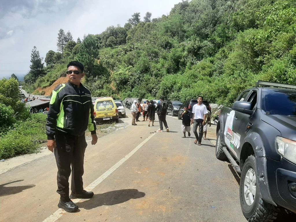 Petugas kepolisian dari Ditlantas Polda Sulsel mengatur kendaraan di sekitar lokasi longsor Kecamatan Bastem Utara, Luwu, Sulawesi Selatan, Senin (26/2/2024). Longsor tak hanya menimbulkan korban jiwa, tapi juga membuat arus lalu lintas  lumpuh. 