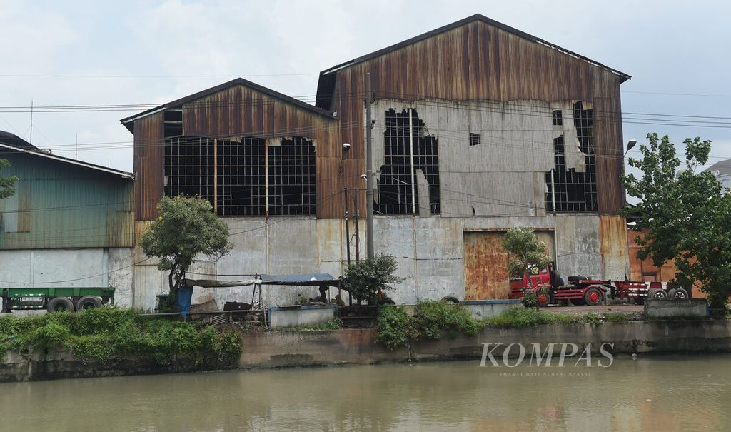 Gudang rusak di Kalimas Timur, Surabaya, Jawa Timur, Senin (30/1/2023). Pada masa Hindia Belanda, kawasan di hulu Sungai Kalimas merupakan pusat perekonomian. Pada masa itu banyak dibangun pabrik serta gedung perkantoran. Saat ini gedung-gedung bernilai sejarah tersebut banyak yang mangkrak. 