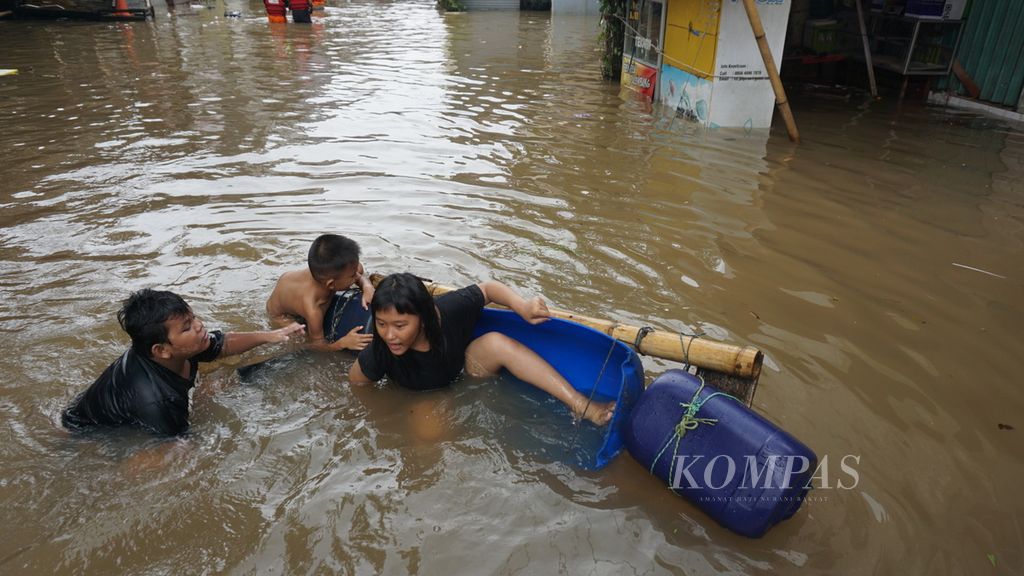 Anak-anak bermain di tengah banjir di Jalan Kemang Utara, Kelurahan Bangka, Mampang Prapatan, Jakarta Selatan, Selasa (25/2/2020). Puluhan rumah wilayah ini terendam banjir dengan ketinggian mencapai 1,5 meter.