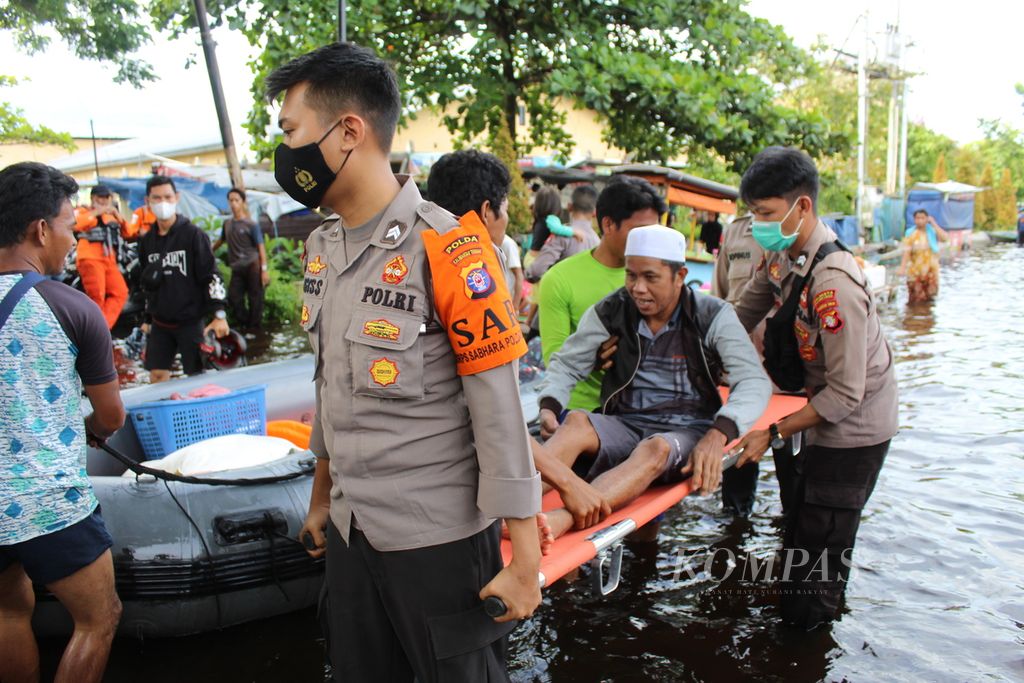 Petugas dari Kepolisian Daerah Kalimantan Tengah dan para sukarelawan mengevakuasi Karya (50), warga Mendawai Ujung, Kota Palangkaraya, Kalteng, yang menderita penyakit stroke, pertengahan November 2021. 