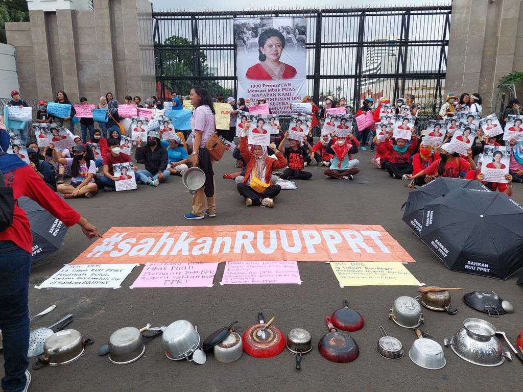 Memperingati Hari Perempuan Internasional, Koalisi Sipil untuk UU PPRT menggelar aksi di depan pintu gerbang kantor Parlemen Senayan, Rabu (8/3/2023), dengan membentangkan membawa poster dan alat rumah tangga. Mereka mendesak Ketua DPR Puan Maharani segera mengesahkan RUU PPRT.
