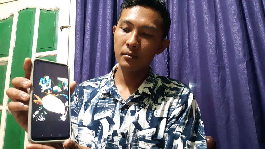 Adi Saputra, ABK asal Kabupaten Cirebon, Jawa Barat, menunjukkan foto-fotonya semasa kerja di kapal China, Minggu (30/7/2023).
