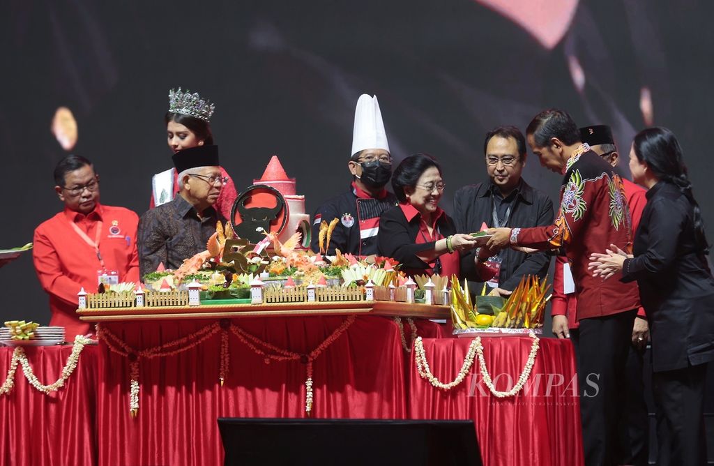 President Joko Widodo (second from right) accompanied by Vice President Ma'ruf Amin (second from left) receives <i>nasi tumpeng</i> (rice cone) from PDI Perjuangan Chairperson Megawati Soekarnoputri (center) at the peak of the PDI Perjuangan 50th Anniversary event in Jakarta, Tuesday (10/1 /2023).