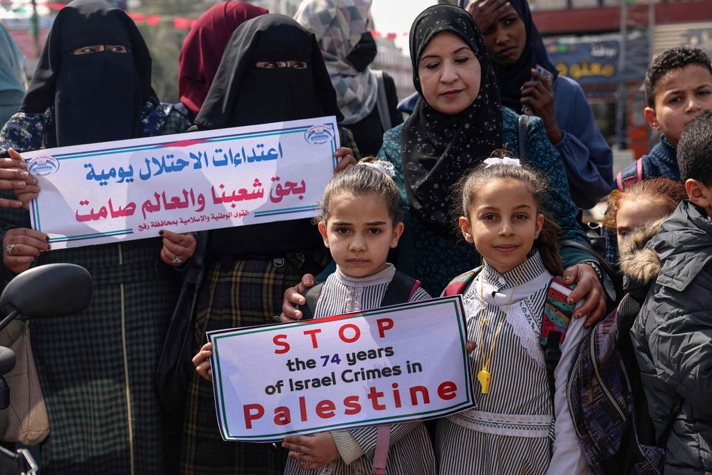 Warga Palestina membentangkan poster saat berdemonstrasi untuk menggalang dukungan internasional terhadap perjuangan Palestina melawan Israel di kamp pengungsi Rafah di selatan Jalur Gaza, Senin (7/3/2022). Mereka mengharapkan dukungan internasional seperti dukungan terhadap Ukraina yang sedang berjuang melawan serangan Rusia.