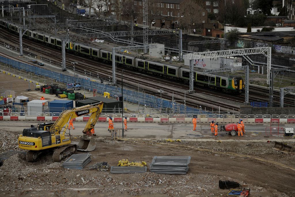 Sebuah kereta melintasi proyek konstruksi kereta cepat High Speed 2 (HS2) di Stasiun Euston, London, Inggris, Selasa (11/2/2020). Pemerintah Inggris, Minggu (24/9/2023), menyatakan kemungkinan untuk memperpendek rute proyek setelah anggaran proyek membengkak.  