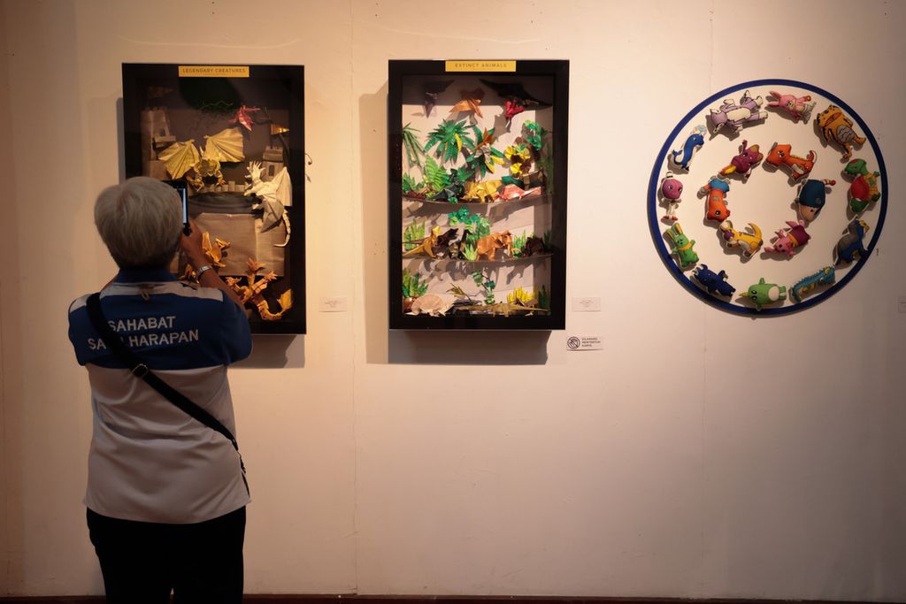 Seorang pengunjung memotret karya seni berupa origami yang dipamerkan di acara pameran seni rupa bertajuk Bianglala Seribu Imajinasi” di Bentara Budaya Jakarta, Rabu (5/3/2023). 