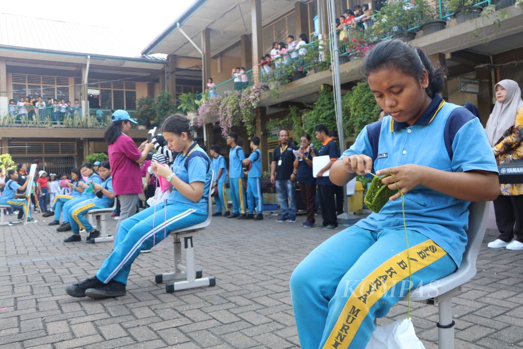 Anak tunarungu dari Sekolah Luar Biasa-B Yayasan karya Murni membuat kerajinan kain rajutan dalam kampanye Kami Membunyikan Lonceng di SD Antonius 1 dan 2, di Medan, Sumatera Utara, Sabtu (9/9/2023). Kampanye itu dilakukan untuk menarik perhatian dunia pada pendidikan anak dengan disabilitas.