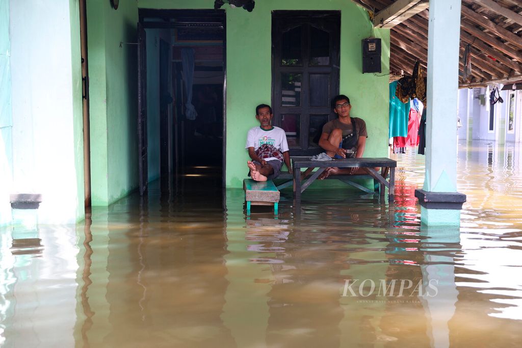 Warga bertahan untuk menjaga rumah mereka selama banjir terjadi dalam beberapa hari ini di Tanggulangin, Desa Jati Wetan, Kecamatan Jati, Kabupaten Kudus, Jawa Tengah, Rabu (4/1/2023).