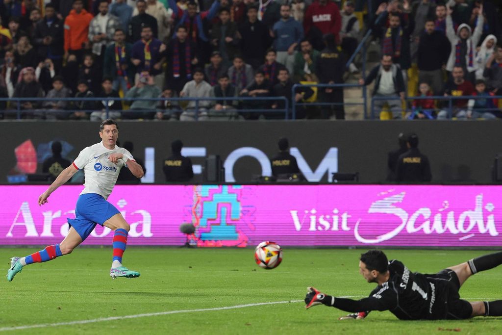 Kiper Osasuna Sergio Herrera menepis bola tendangan Robert Lewandowski (kiri) pada laga melawan Osasuna pada semifinal Piala Super Spanyol di Stadion Al-Awwal Park, Riyadh, Kamis (11/1/2024). Barcelona menang 2-0 pada laga itu.