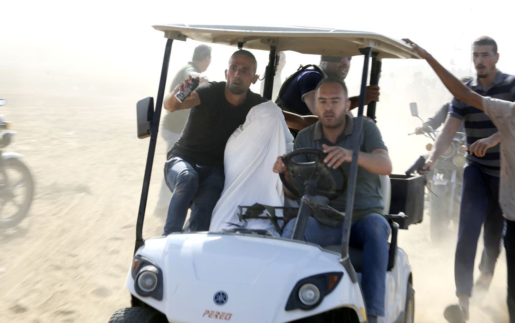 Sejumlah laki-laki warga Palestina yang diduga adalah anggota kelompok Hamas dan sayap militernya membawa seorang yang diduga warga Israel dengan menggunakan kendaraan golf ke Jalur Gaza, Sabtu (7/10/2023). 