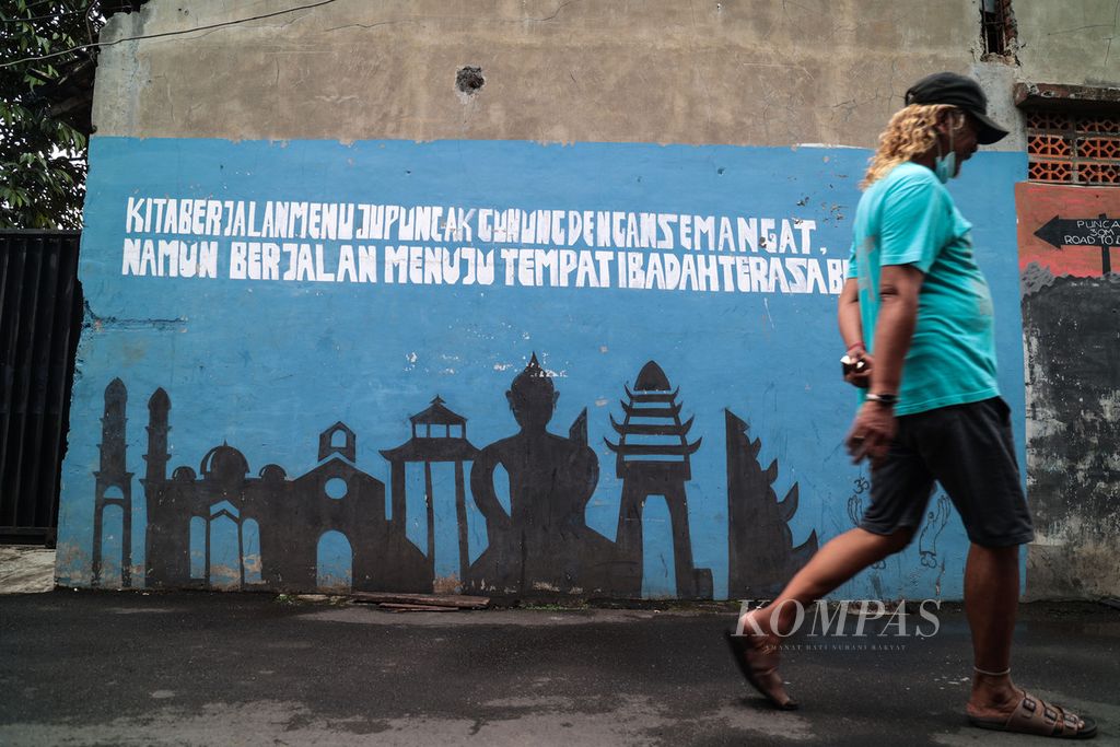 Mural bertema toleransi antarumat beragama tergambar di gang pintu masuk sebuah masjid di kawasan Cipedak, Jakarta, Kamis (13/10/2022). 