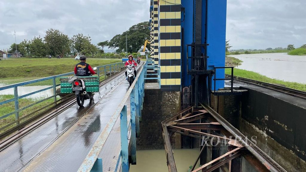 Warga melintasi jembatan Pintu Banjir Wilalung, Kudus, Jawa Tengah, Kamis (2/3/2023), sekitar pukul 11.04 WIB.