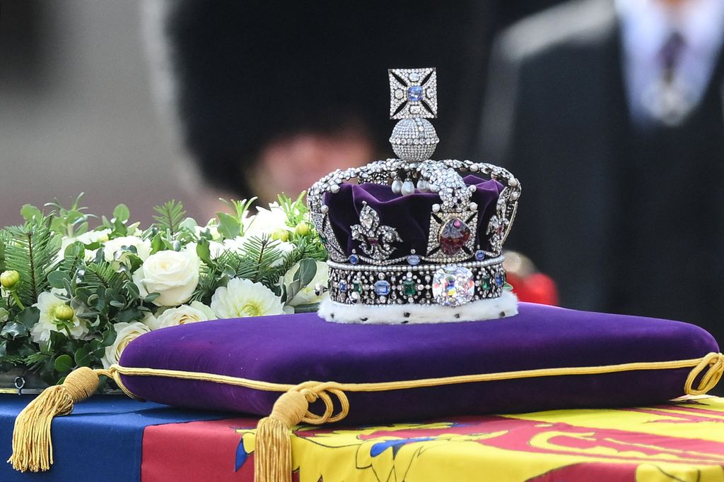 Mahkota Kerajaan diletakkan di atas peti jenazah ratu Elizabeth II saat diarak dalam prosesi dari Istana Buckingham ke Westminster Hall di London, Inggris, Rabu (14/9/2022). 