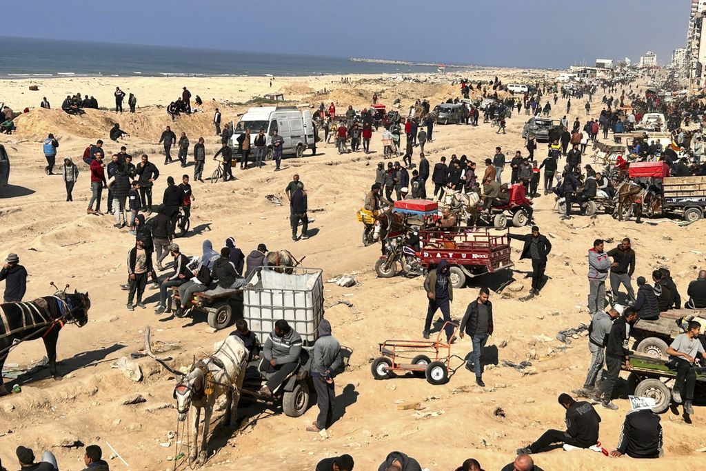 Warga Palestina menanti bantuan kemanusiaan di tepi pantai di Kota Gaza, 25 Februari 2024. 