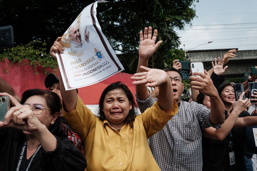  Warga melambai ke kendaraan Paus Fransiskus di dekat Kedutaan Besar Vatikan di Jakarta, Rabu (4/9/2024). Paus berusia 87 tahun itu tampak dalam keadaan sehat dan semangat saat dia bertemu Presiden Indonesia. 