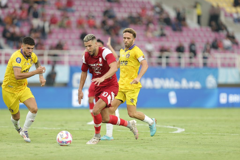 Striker Persis Solo, Karim Rossi (merah), menggiring bola di antara para pemain Persik Kediri dalam lanjutan Liga 1 2024/2025 di Stadion Manahan, Kota Surakarta, Jawa Tengah, Senin (23/9/2024). Laga itu dimenangi Persik Kediri dengan skor akhir 1-0. 