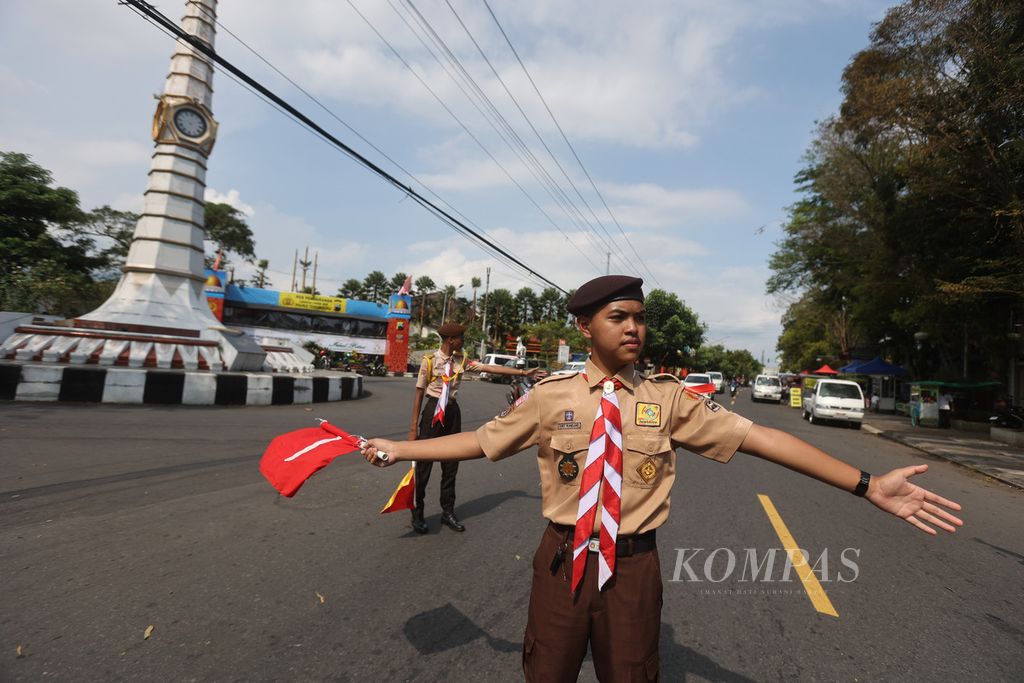 Anggota Pramuka membantu mengatur arus lalu lintas di simpang Tugu Jam, Temanggung, Jawa Tengah, Rabu (19/4/2023). 