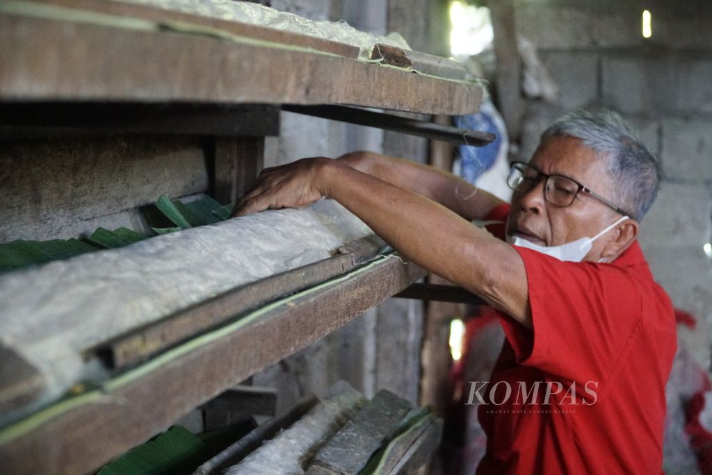 Perajin merapikan letak tempe yang sudah dicetak di pabrik tempe Darek Ani Cap Gunung Tiga, Kelurahan Alai Parak Kopi, Kota Padang, Sumatera Barat, Minggu (20/2/2022).