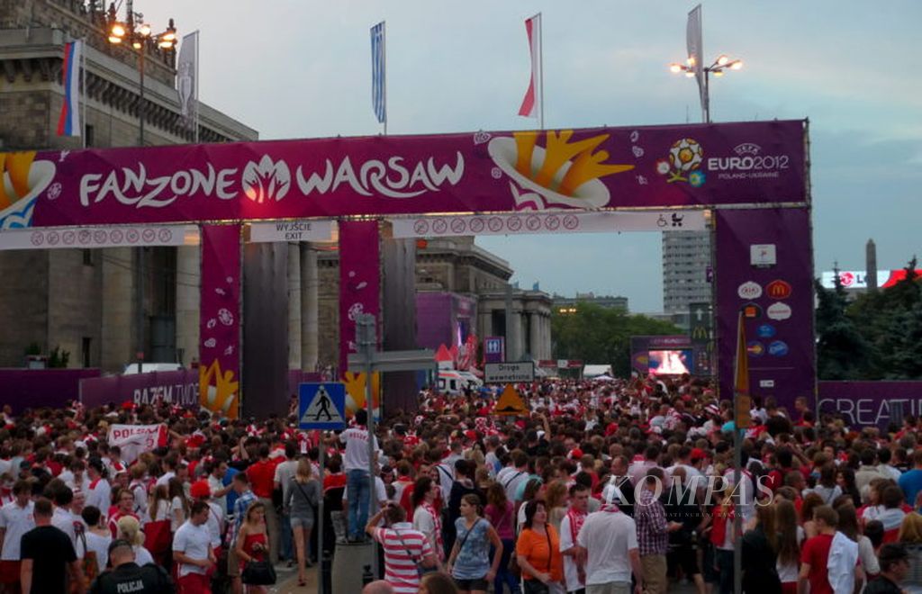 Pengunjung yang berada di zona suporter di Warsawa, Polandia, membeludak hingga ke luar gerbang. Mereka sebagian besar fans Polandia yang akan menyaksikan duel Polandia melawan Ceko pada laga terakhir penyisihan Grup A Piala Eropa 2012, Sabtu (16/6/2012). Polandia kalah 0-1 dari Ceko dan tersingkir dari Piala Eropa 2012. Acara menonton bareng itu menjadi pesta terakhir mereka.