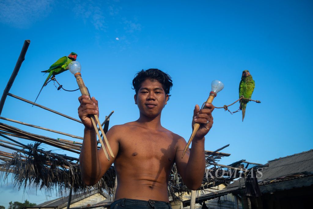 A resident of the Sea Tribe, Erwin, shows a parrot (a kind of parrot) in Airframe Village, Tajur Biru Village, Temiang Pesisir District, Lingga Regency, Riau Islands, Monday (18/7/2022).