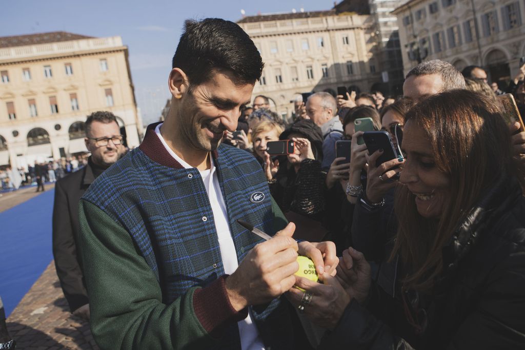 Novak Djokovic menandatangani bola tenis permintaan penggemar pada acara perkenalan pemain Final ATP di Turin, Italia, 11 November 2022. Djokovic ingin menutup tahun 2022 dengan gelar juara di Turin.