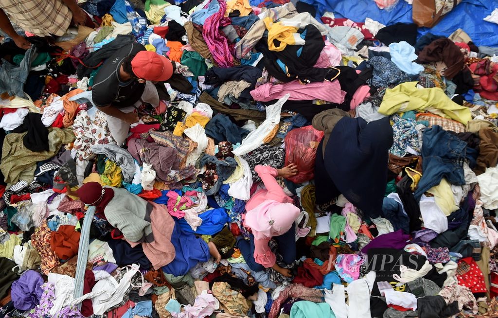 Warga terdampak erupsi Gunung Semeru memilih pakaian bekas dari donatur di halaman SD Negeri Supiturang 1, Kecamatan Pronojiwo, Kabupaten Lumajang, Senin (13/12/2021).