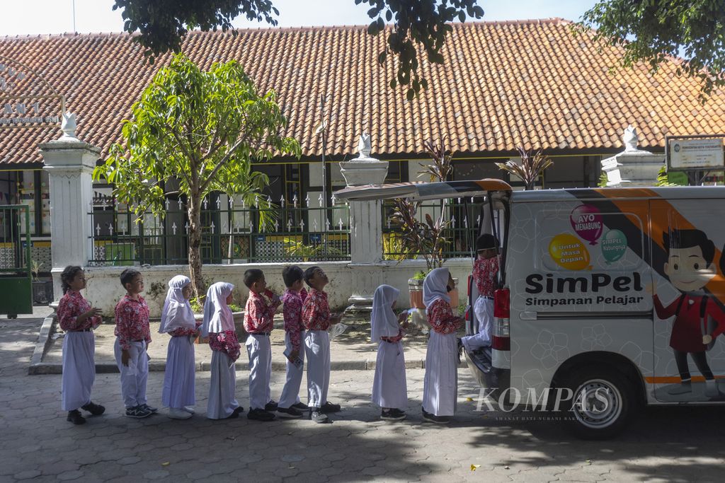Murid kelas 1 SD Negeri Keputran 1 menabung melalui layanan mobil kas keliling Bank Jogja yang singgah di sekolah mereka di Kecamatan Kraton, Yogyakarta, Kamis (22/2/2024). 