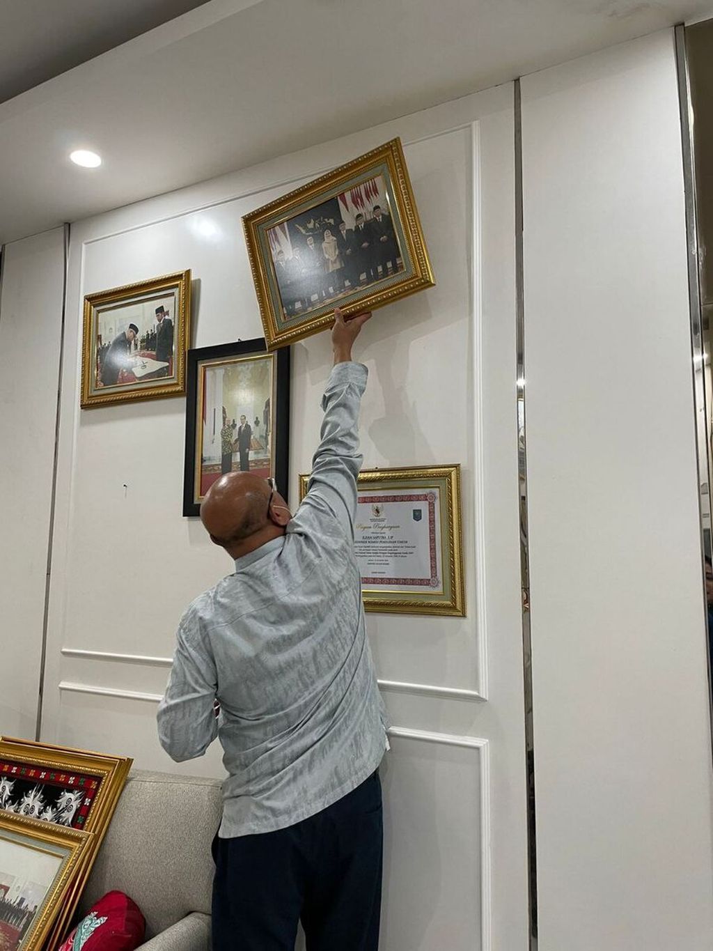 Ketua Komisi Pemilihan Umum (KPU) periode 2017-2022 Ilham Saputra mencopoti foto pribadi, piagam penghargaan, dan hiasan dinding di hari terakhir masa jabatannya, Senin (11/4/2022).