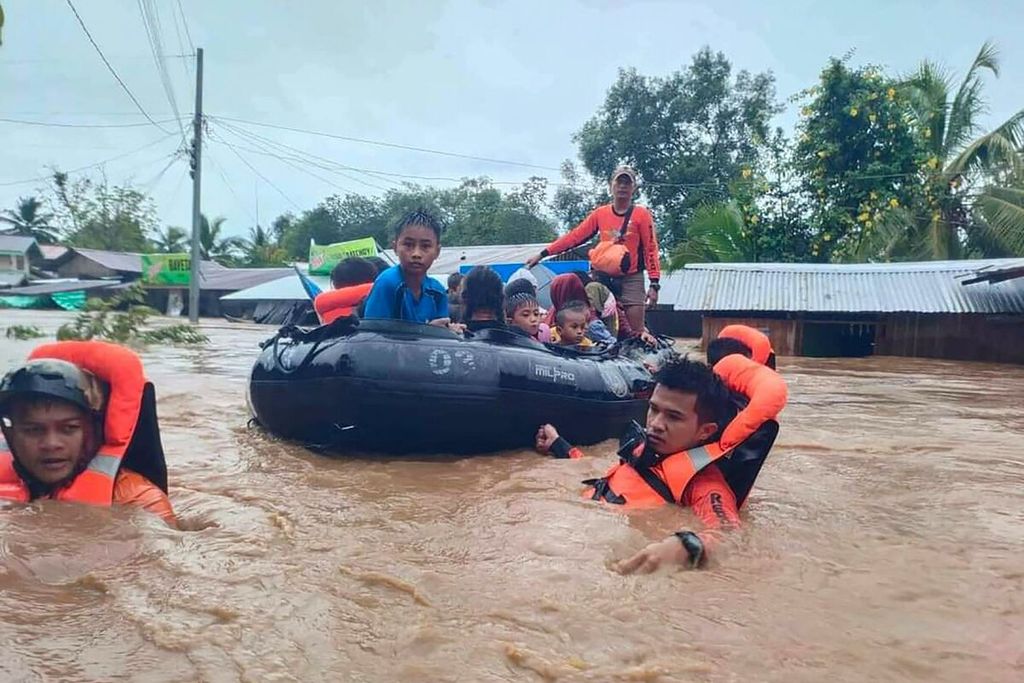 Dalam foto yang dirilis oleh Penjaga Pantai Filipina pada Jumat (28/10/2022) tampak tim penyelamat mengevakuasi warga dari Parang, Provinsi Maguindanao, salah satu wilayah yang terkena banjir, 