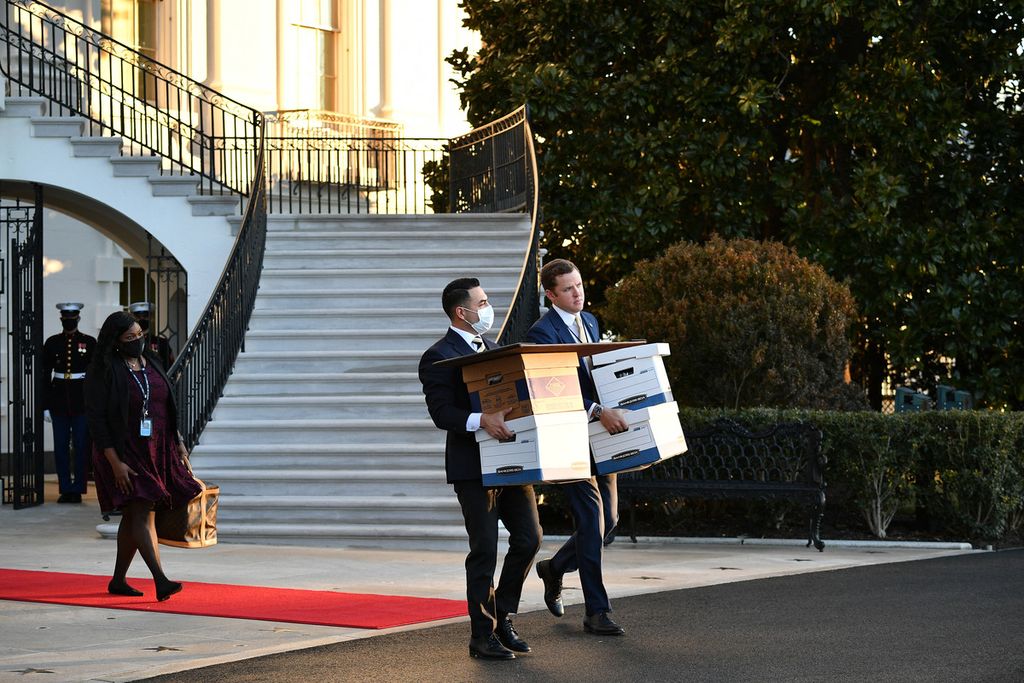 Foto pada 20 Januari 2021 menunjukkan para asisten membawa kotak ke Marine One sebelum Presiden Amerika Serikat Donald Trump dan istrinya, Melania, berangkat dari Gedung Putih pada hari terakhir Trump menjabat di Washington, DC. 