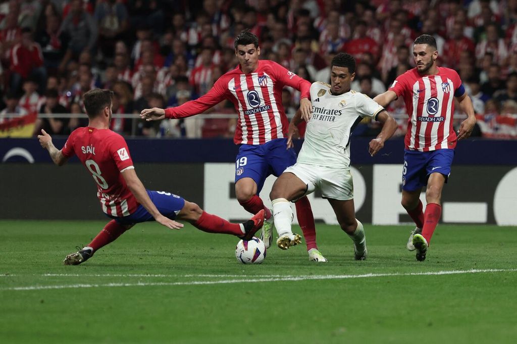 Gelandang Atletico Madrid Saul Niguez menghadang penyerang Real Madrid Jude Bellingham pada laga Liga Spanyol, Senin (25/9/2023) dini hari WIB. 
