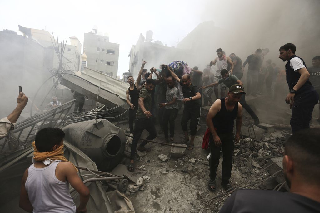 Warga Palestina mengeluarkan mayat dari reruntuhan bangunan setelah serangan udara Israel di kamp pengungsi Jebaliya, Jalur Gaza, Senin (9/10/2023). 