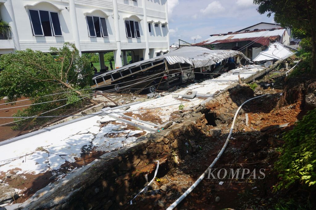 Tujuh unit kendaraan dinas Perusahaan Umum Daerah Air Minum Tirta Perwira Purbalingga tertimpa atap setelah tembok keliling di sekitarnya ambruk tergerus aliran air sungai pada Kamis (4/4/2024).