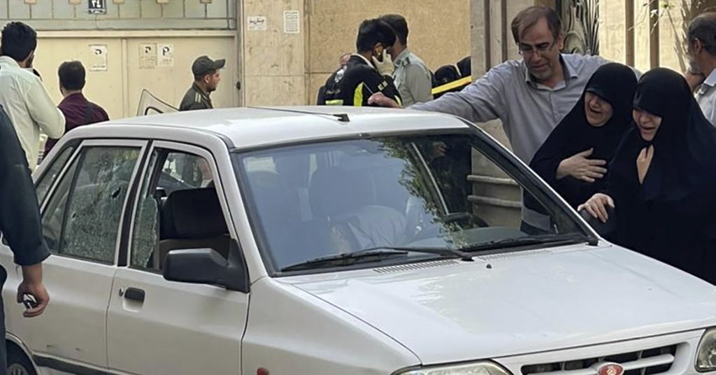 Keluarga Kolonel Sayyad Khodaei, perwira senior Korps Garda Revolusi Iran (IRGC), menangis di dekat jenazah Khodaei yang berada di dalam mobil. Khodaei tewas ditembak oleh dua pengendara sepeda motor di Teheran, Iran, Minggu (22/5/2022). 