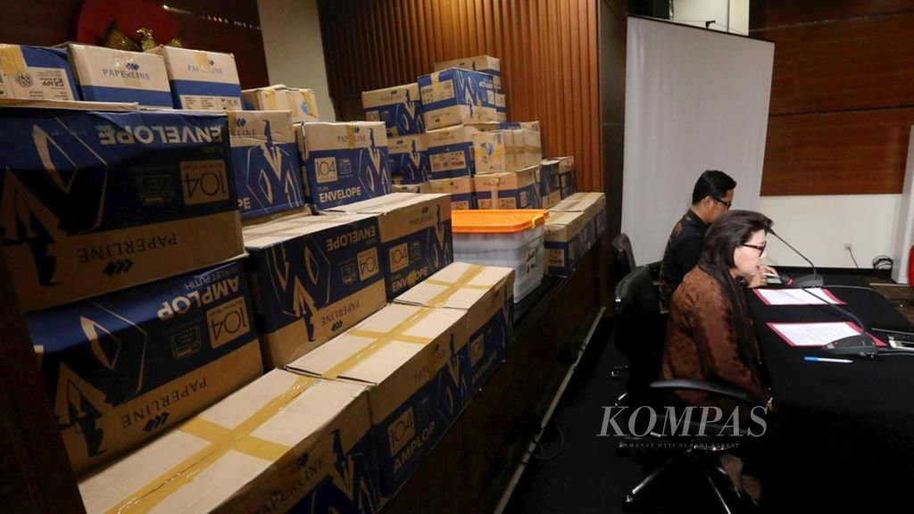 Wakil Ketua KPK Basariah Panjaitan (kanan) memberikan keterangan kronologis operasi tangkap tangan Di kantor KPK, Jakarta, dengan latar belakang 84 kardus berisi uang lebih dari Rp 8 miliar sebagai barang bukti, Kamis (28/3/2019).
