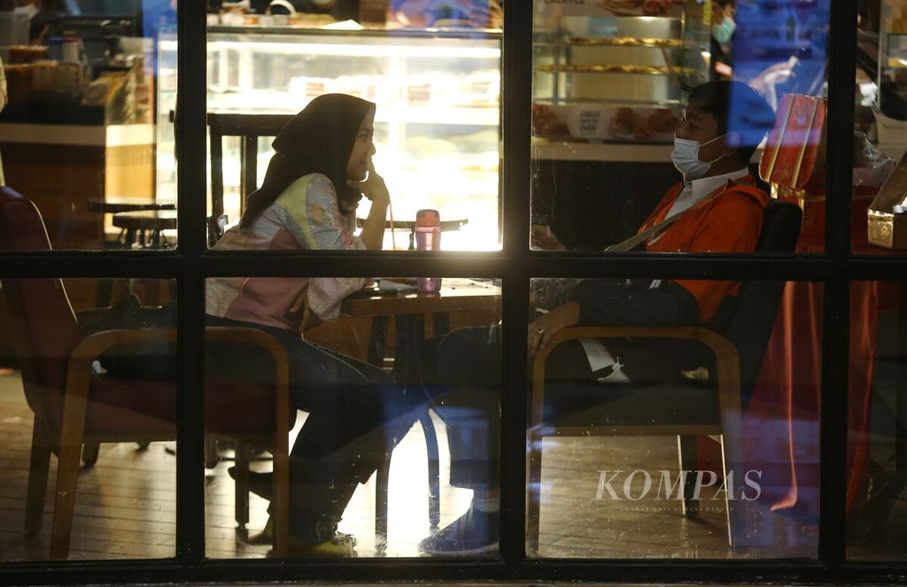 Pekerja muda nongkrong di sebuah kafe di kawasan Kelapa Gading, Jakarta, Kamis (27/1/2022). Kebijakan dalam mengelola keuangan diperlukan oleh pekerja muda agar tetap memiliki tabungan. 